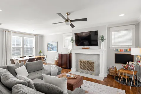a living room with furniture a flat screen tv and a fireplace