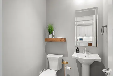 a bathroom with a toilet a sink and mirror