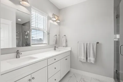a bathroom with a double vanity sink and a mirror