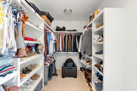 a view of walk in closet with clothes and shoes