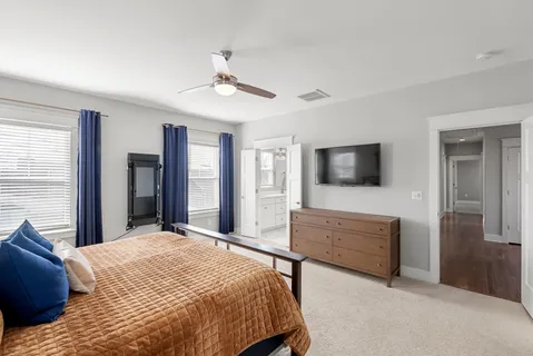 a spacious bedroom with a bed and a flat screen tv
