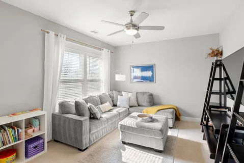 a living room with furniture a ceiling fan and a window