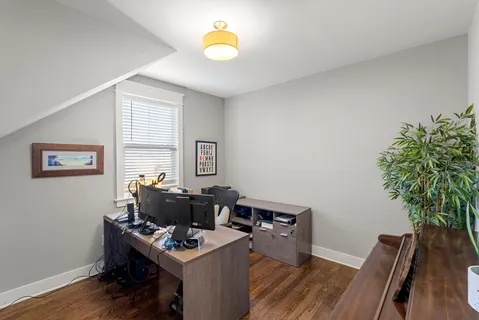 a view of a workspace with furniture and a window