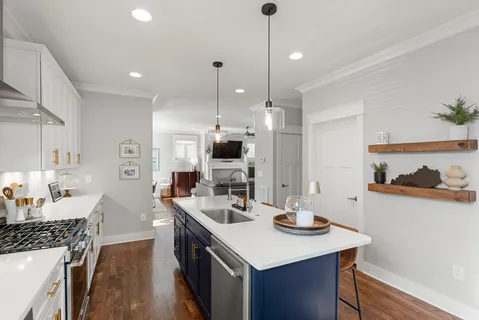 a kitchen with stainless steel appliances kitchen island granite countertop a sink a stove and a refrigerator