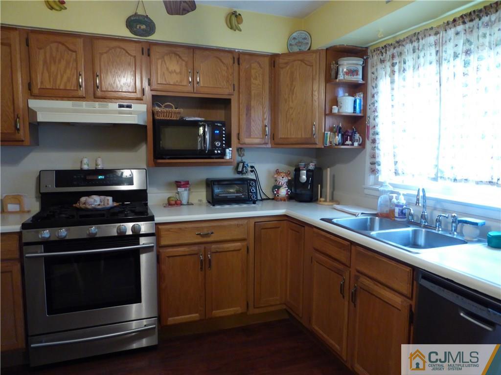 102 Stony Road Edison, NJ 08817 - Photo 7 of 21 a kitchen with stainless steel appliances wooden cabinets and a stove top oven