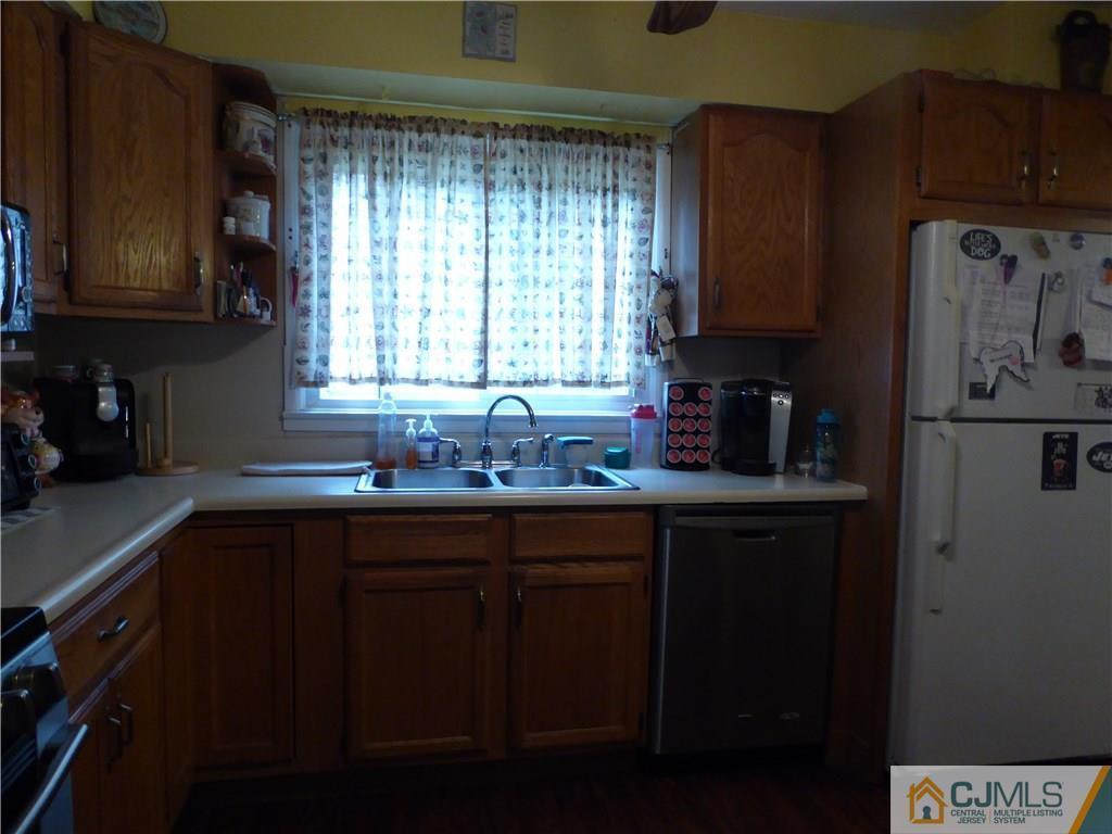 102 Stony Road Edison, NJ 08817 - Photo 9 of 21 a kitchen with stainless steel appliances a sink dishwasher and cabinets with wooden floor