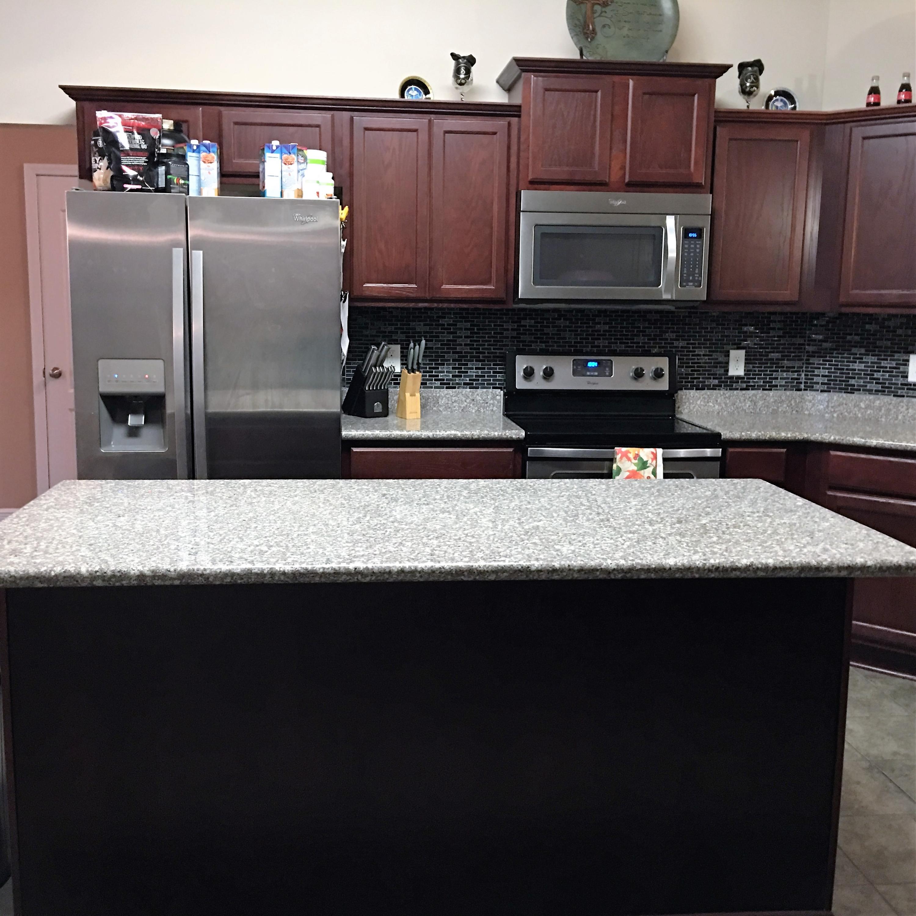 4519 Hermosa Road Crestview, FL 32539 - Photo 8 of 34 a kitchen with granite countertop stainless steel appliances a sink a stove a refrigerator a microwave and cabinets