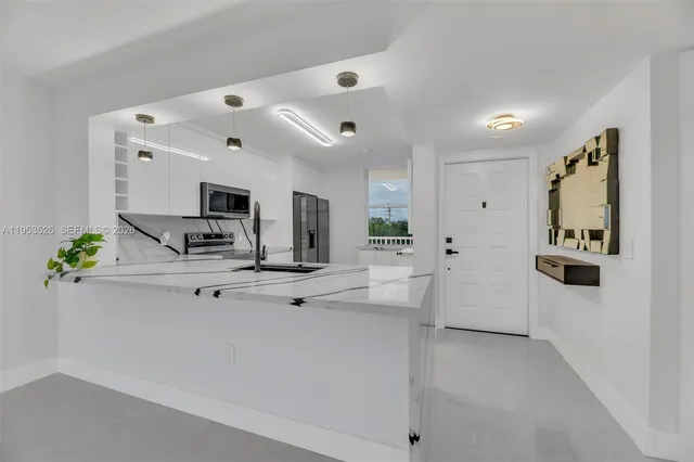 a view of kitchen with sink and refrigerator