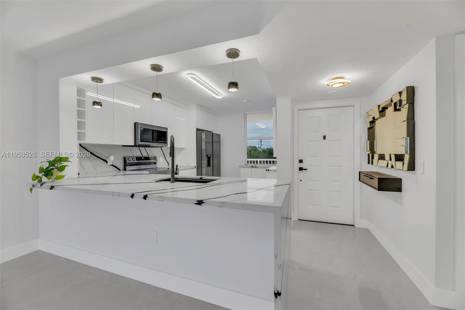 a view of kitchen with sink and refrigerator