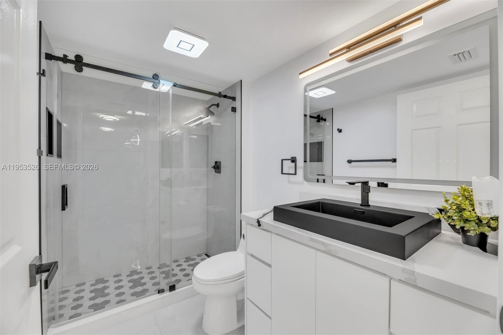 2601 North Nob Hill Road, Unit 407 Sunrise, FL 33322 - Photo 12 of 38 a bathroom with a sink a toilet a mirror and shower