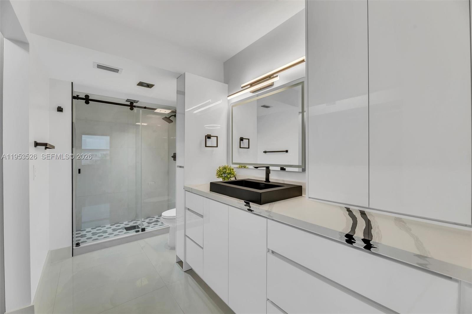 2601 North Nob Hill Road, Unit 407 Sunrise, FL 33322 - Photo 16 of 38 a bathroom with a granite countertop sink a mirror and shower