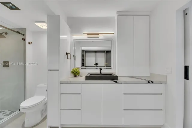 a bathroom with a sink a toilet and shower