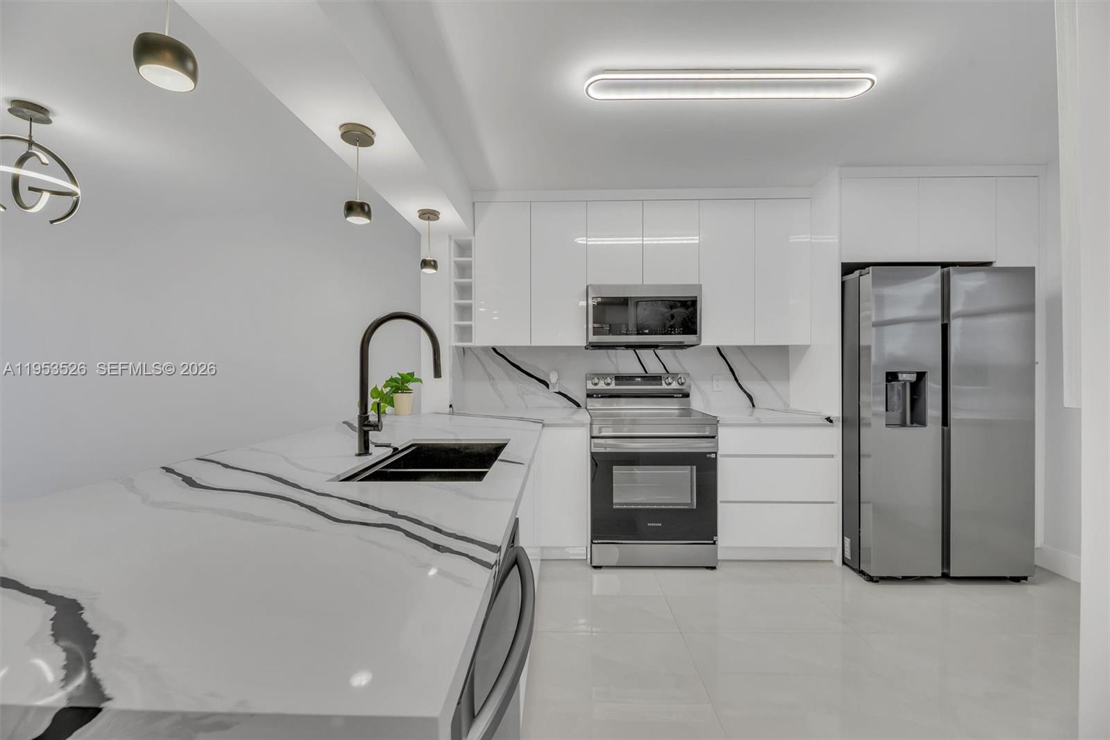 2601 North Nob Hill Road, Unit 407 Sunrise, FL 33322 - Photo 3 of 38 a kitchen with stainless steel appliances a refrigerator sink and stove