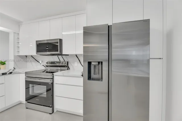 a kitchen with a refrigerator and a stove top oven