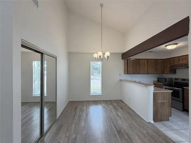 a kitchen with stainless steel appliances granite countertop a stove a refrigerator and a wooden floors