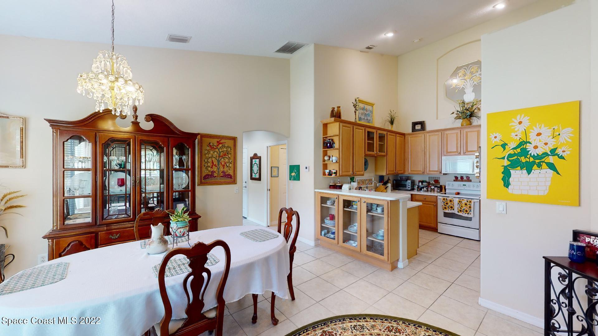 3151 Le Conte Street Melbourne, FL 32940 - Photo 17 of 30 a view of a dining room with furniture chandelier and kitchen view