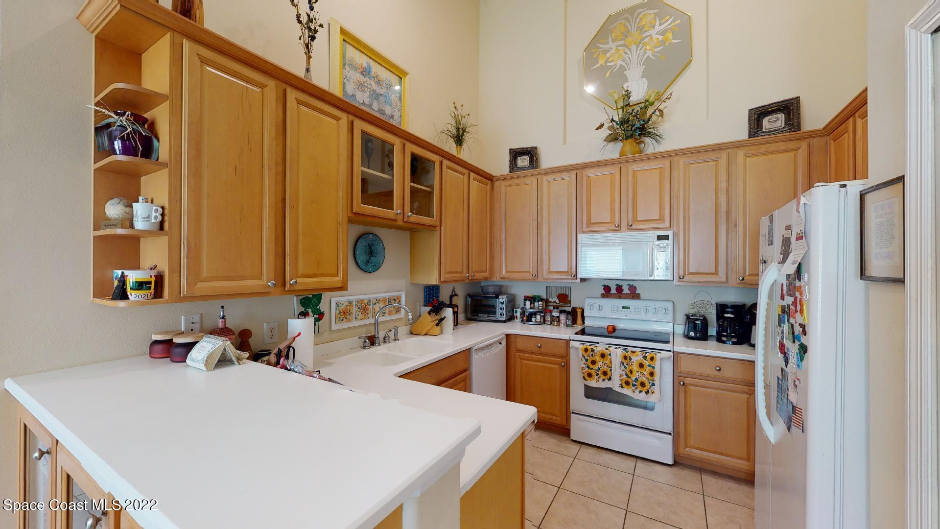 3151 Le Conte Street Melbourne, FL 32940 - Photo 18 of 30 a kitchen with a sink a stove and refrigerator