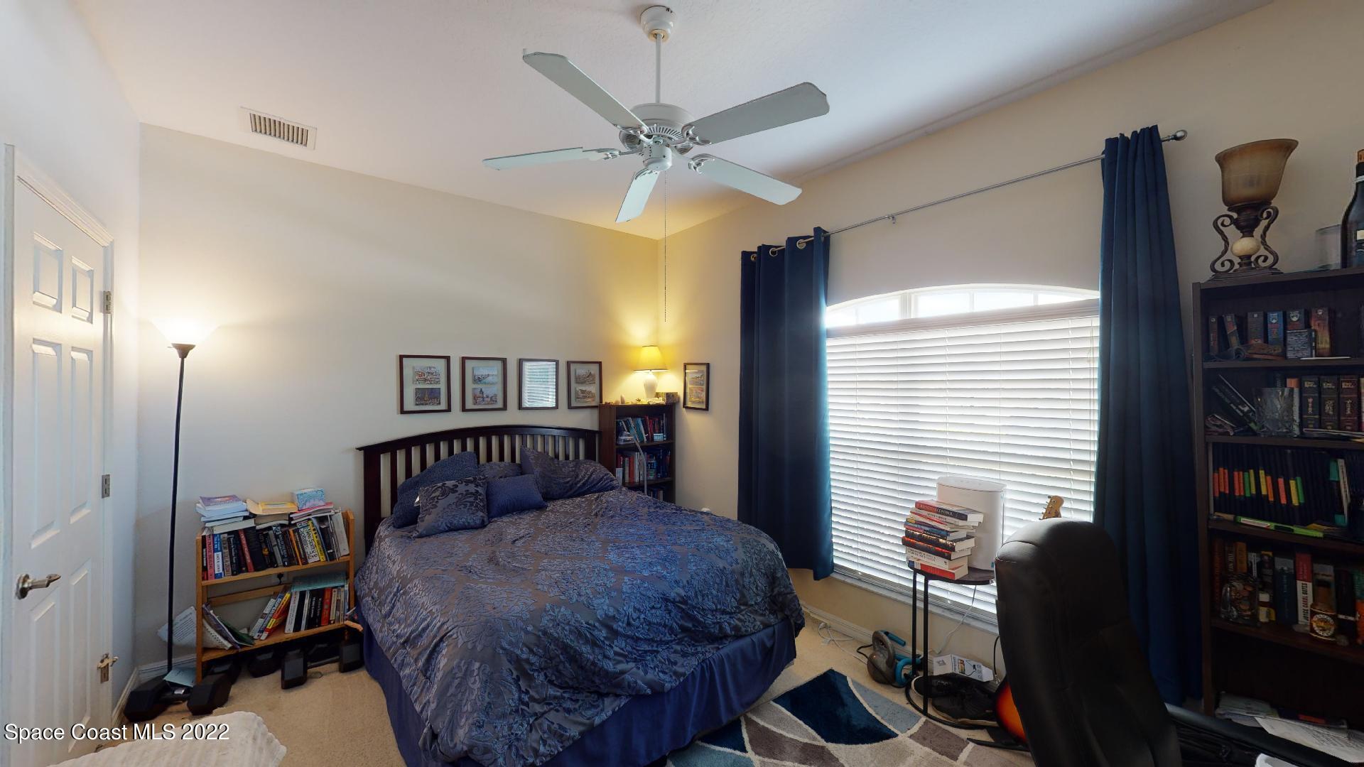 3151 Le Conte Street Melbourne, FL 32940 - Photo 26 of 30 a bedroom with a bed and a chandelier
