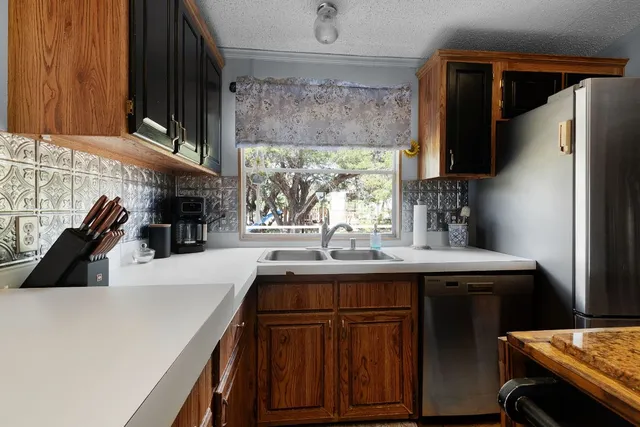 a kitchen with a sink a window and stainless steel appliances