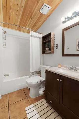 a bathroom with a toilet a sink a mirror and bathtub
