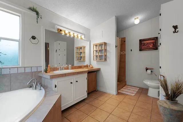 a spacious bathroom with a tub sink and mirror