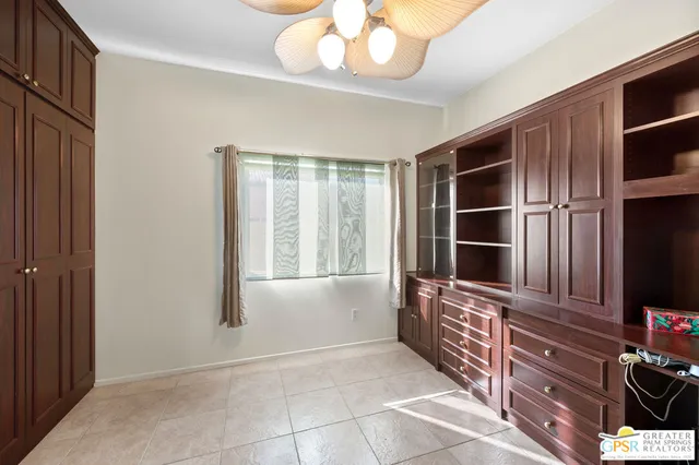 a bedroom with a bed and dresser with wooden floor