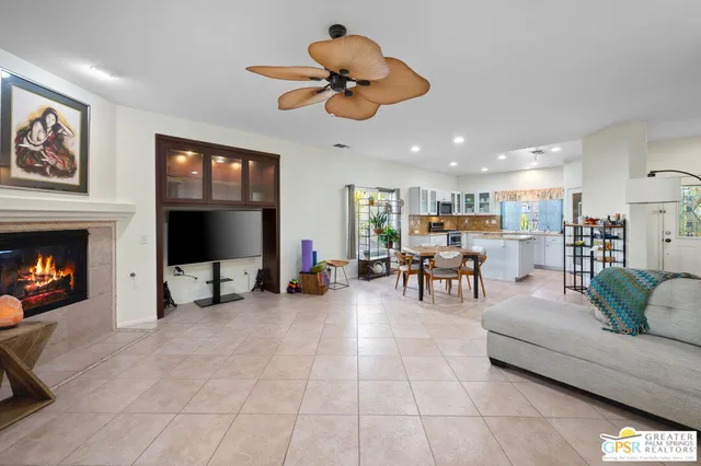 a living room with furniture and a flat screen tv with kitchen view