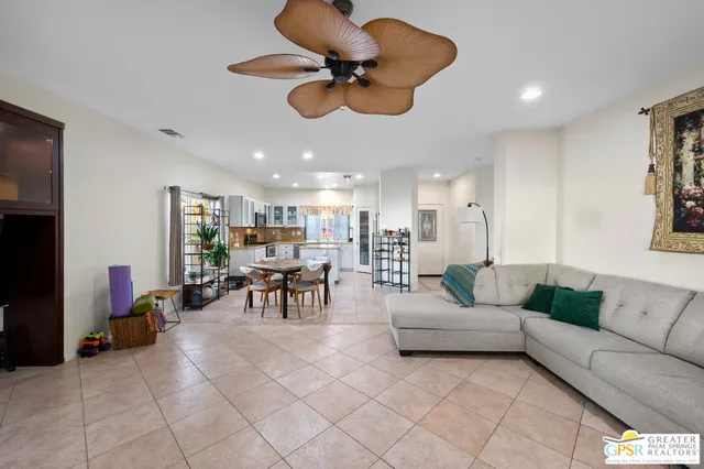 a living room with furniture kitchen view and a chandelier