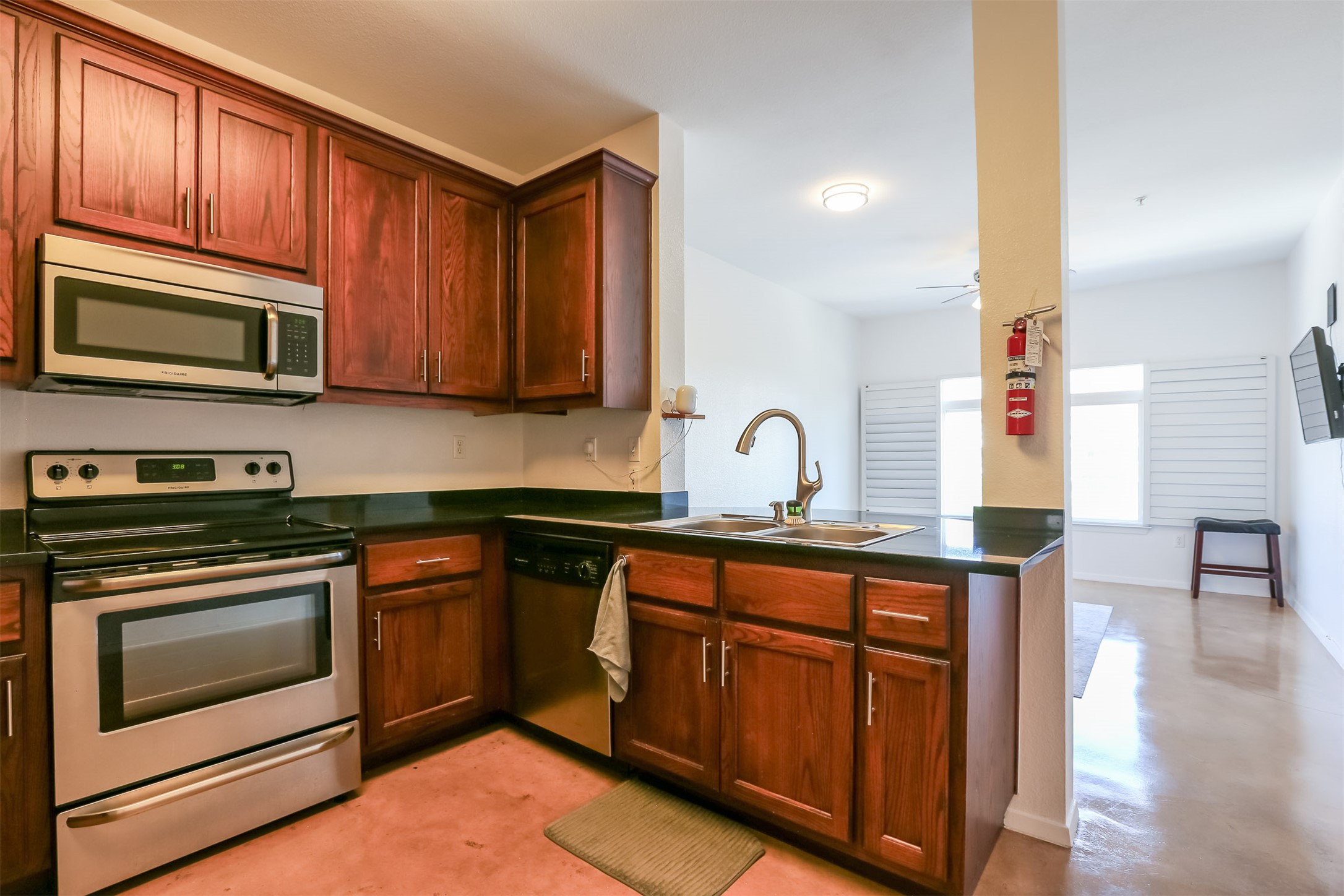 910 West 25th Street, Unit 509 Austin, TX 78705 - Photo 12 of 31 a kitchen with stainless steel appliances granite countertop wooden cabinets a stove a sink and dishwasher with wooden floor