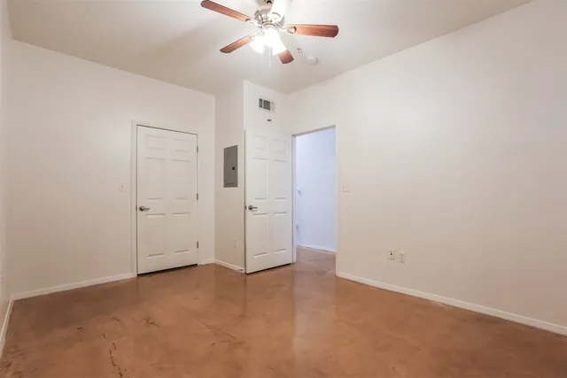 an empty room with chandelier fan