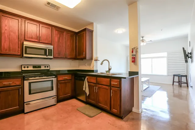 a kitchen with stainless steel appliances granite countertop a stove a sink dishwasher a microwave oven with granite countertops and cabinets