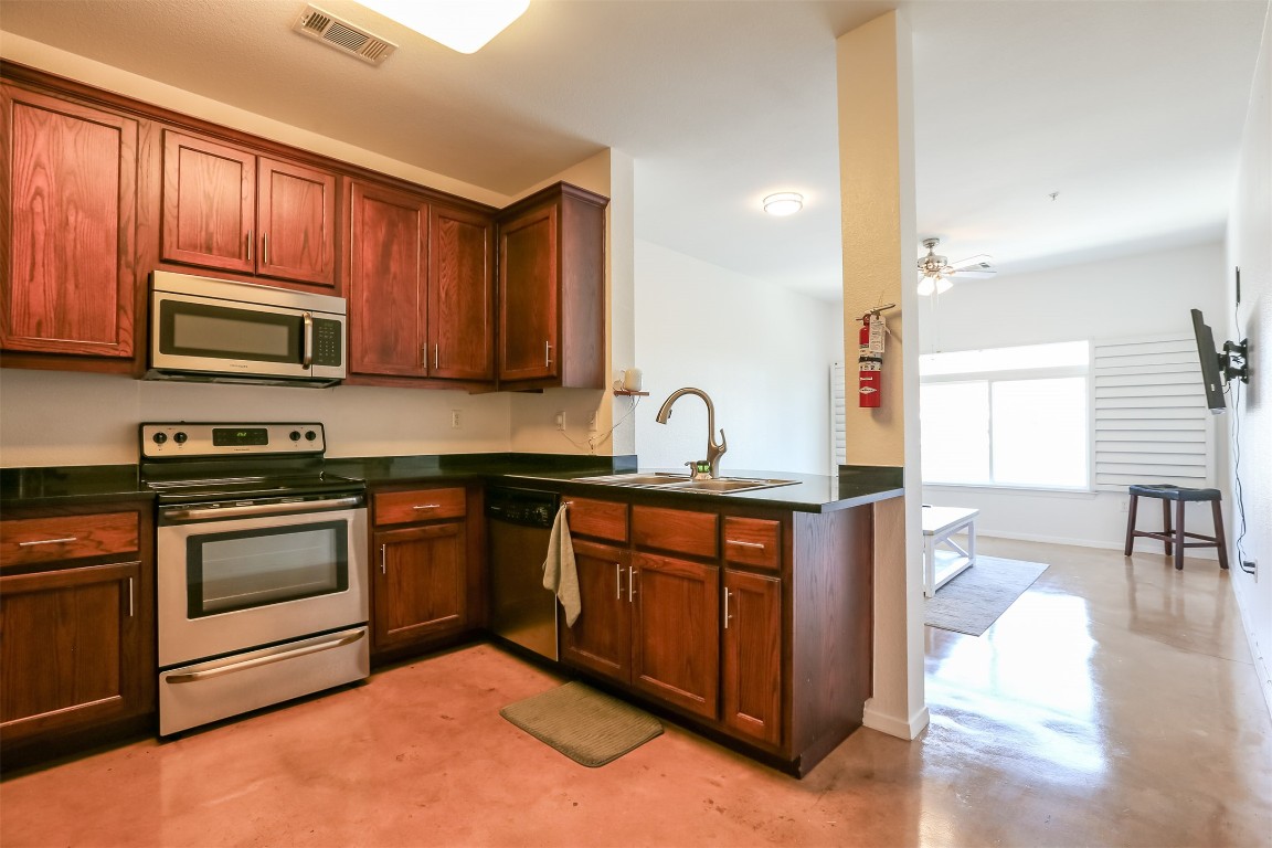 910 West 25th Street, Unit 509 Austin, TX 78705 - Photo 5 of 31 a kitchen with stainless steel appliances granite countertop a stove a sink dishwasher a microwave oven with granite countertops and cabinets