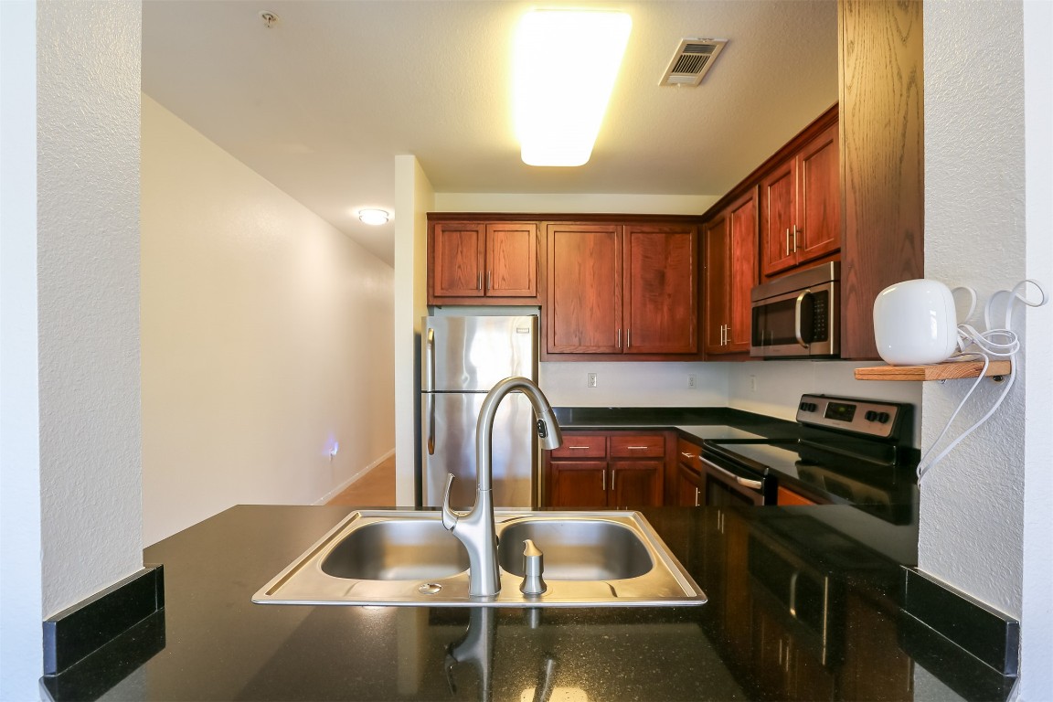 910 West 25th Street, Unit 509 Austin, TX 78705 - Photo 10 of 31 a kitchen with a sink cabinets and a stove
