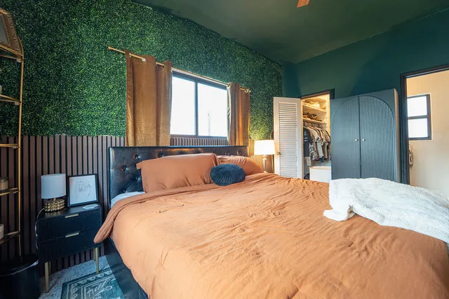 a bed sitting in a bedroom next to a window