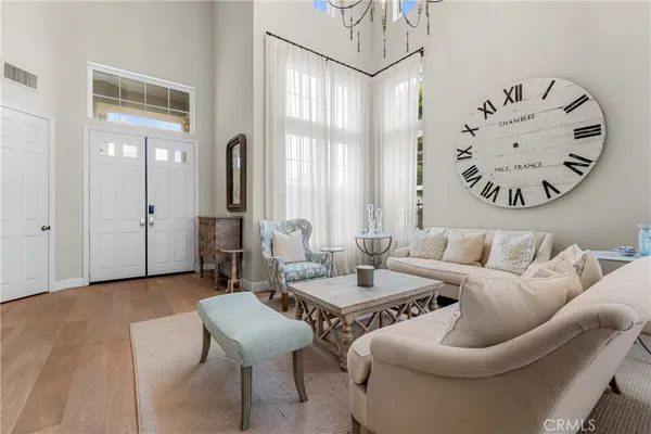 a view of a dining room and livingroom with furniture wooden floor a chandelier