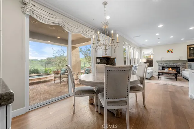 a view of a dining room and livingroom with furniture wooden floor a chandelier