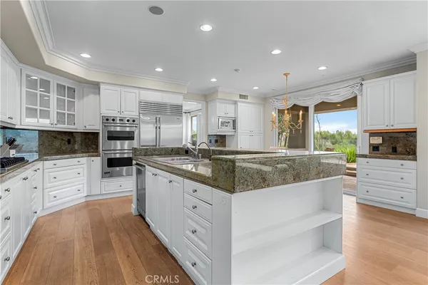 a kitchen with stainless steel appliances granite countertop a sink stove and cabinets