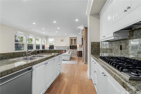 a kitchen with stainless steel appliances kitchen island granite countertop a dining table chairs and granite counter tops