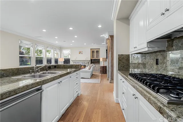 a kitchen with stainless steel appliances granite countertop a sink stove and cabinets