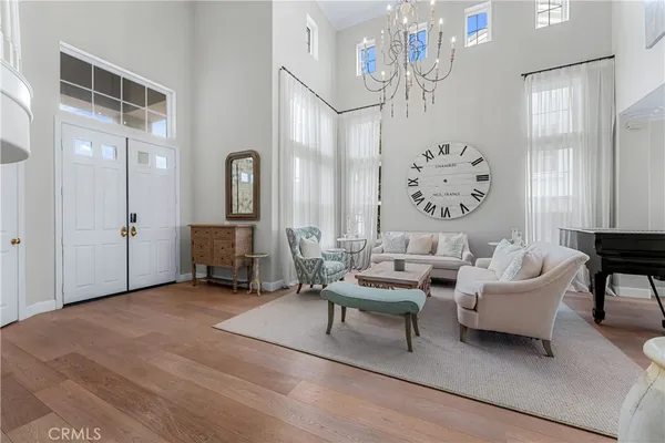 a living room with furniture a chandelier and a painting on the wall