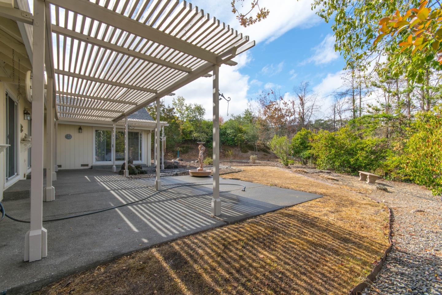 5980 Stone Bridge Road Santa Rosa, CA 95409 - Photo 21 of 24 a view of a patio with table and chairs with wooden floor and fence and a yard