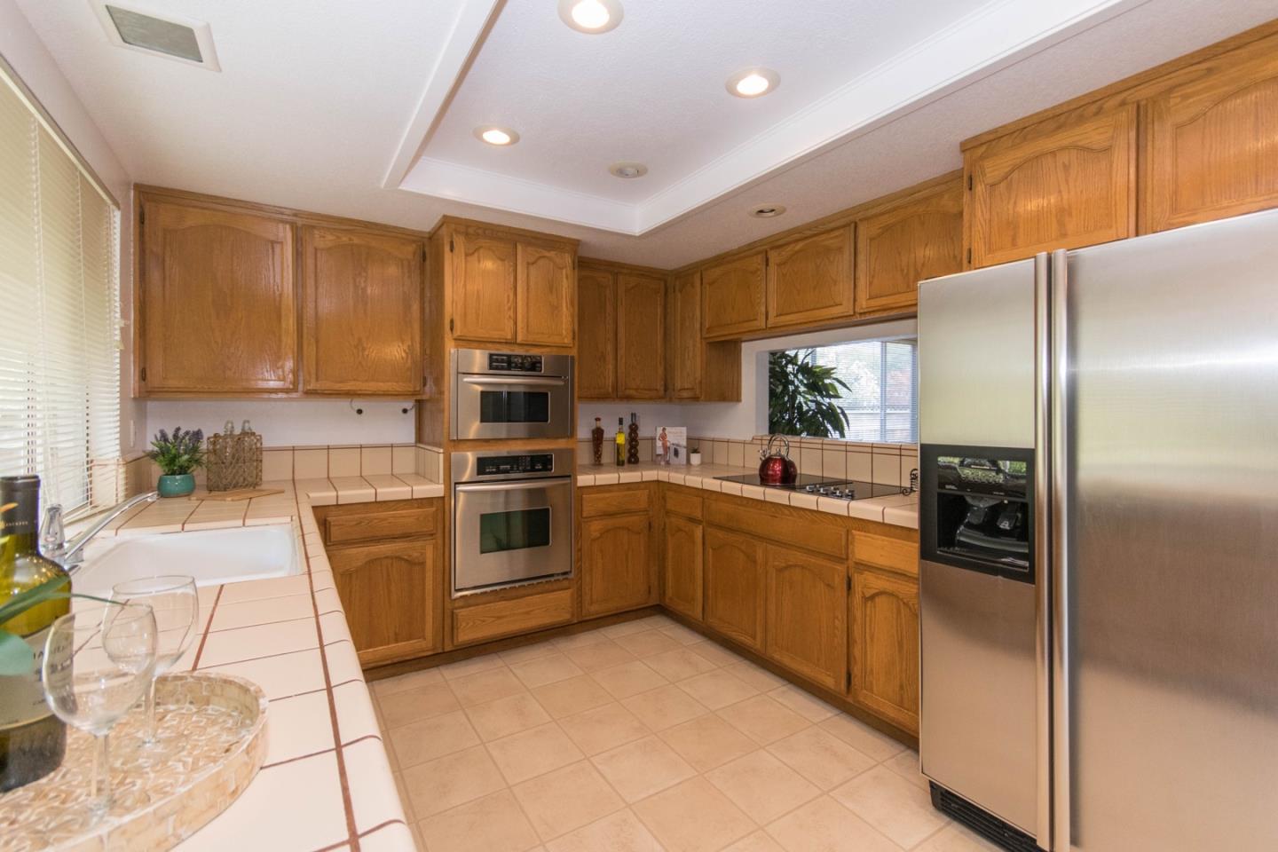 5980 Stone Bridge Road Santa Rosa, CA 95409 - Photo 6 of 24 a kitchen with stainless steel appliances granite countertop a refrigerator a stove and a sink with wooden floor