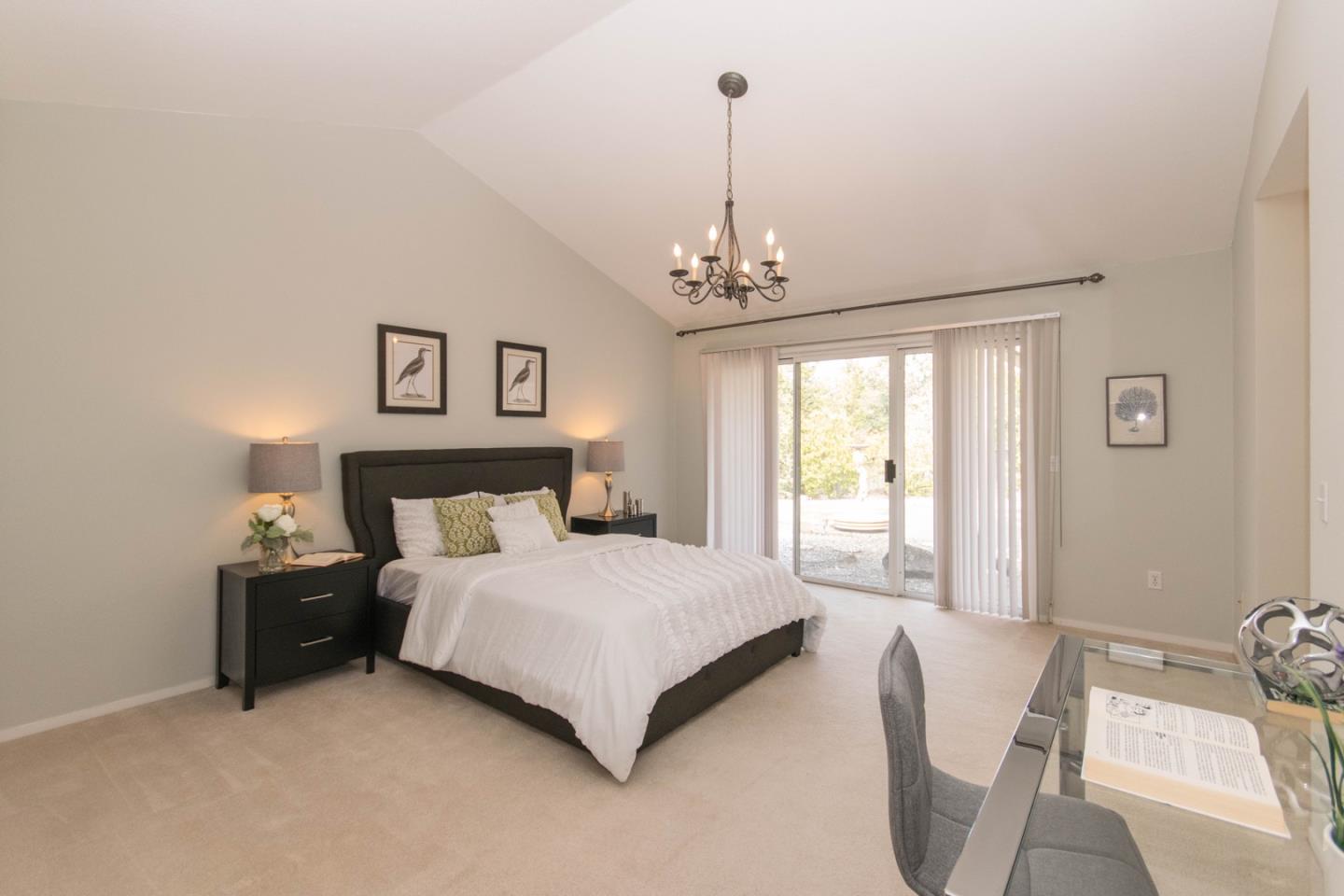 5980 Stone Bridge Road Santa Rosa, CA 95409 - Photo 10 of 24 a spacious bedroom with a bed and a chandelier