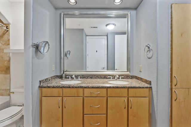 an empty room with chandelier fan and windows