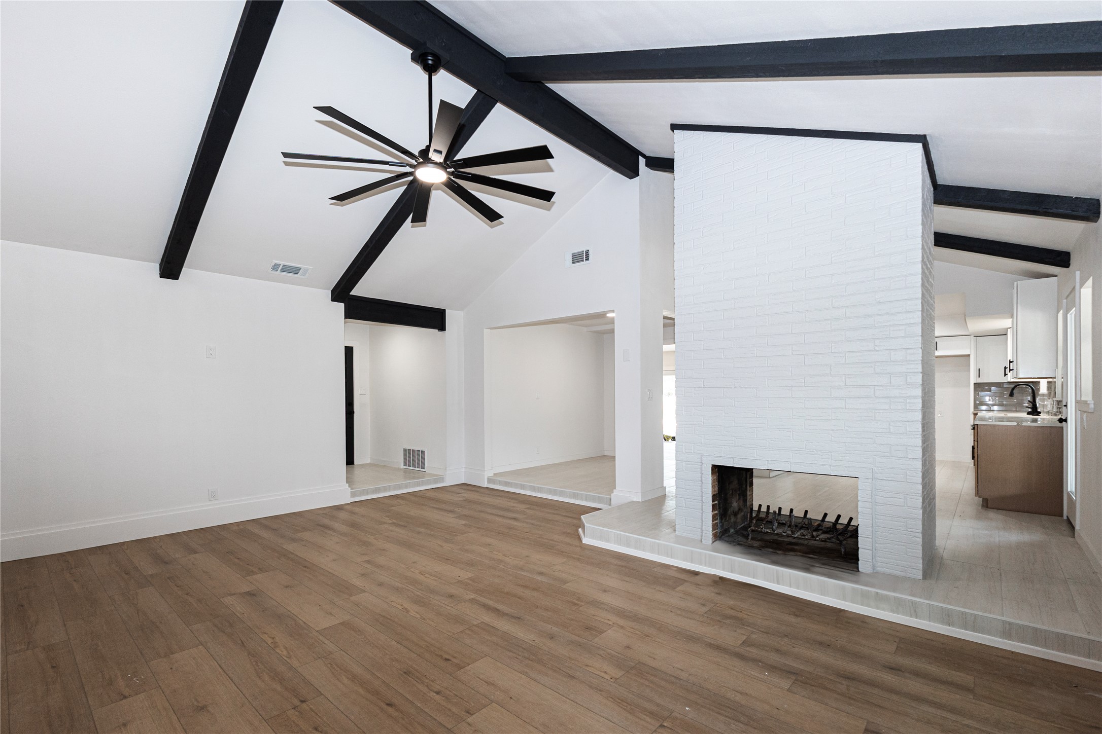205 Bello Circle Georgetown, TX 78628 - Photo 31 of 36 Vast vaulted ceilings with exposed beams and a central fireplace define this airy living space.