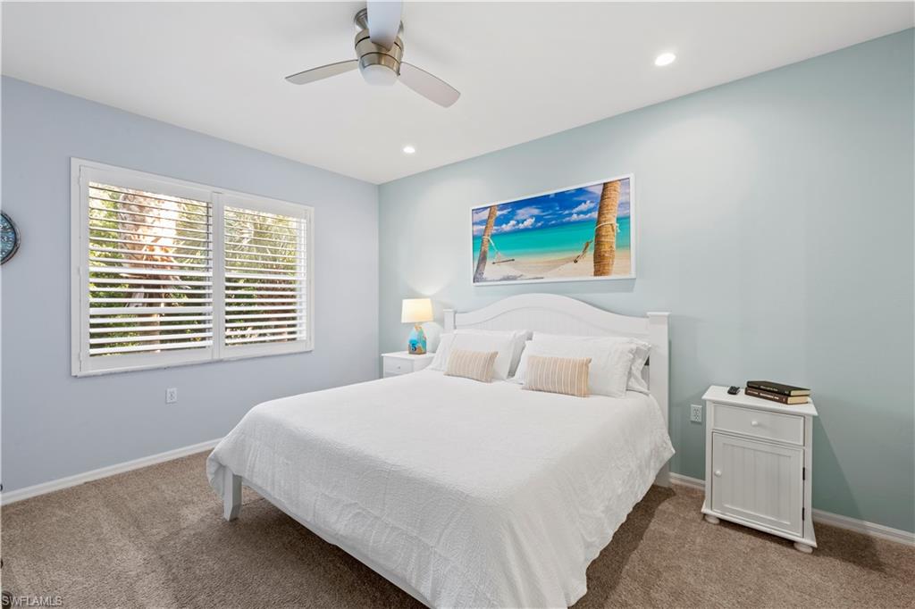 1285 Sweetwater Cove, Unit 2106 Naples, FL 34110 - Photo 13 of 38 a bedroom with a bed and a tv