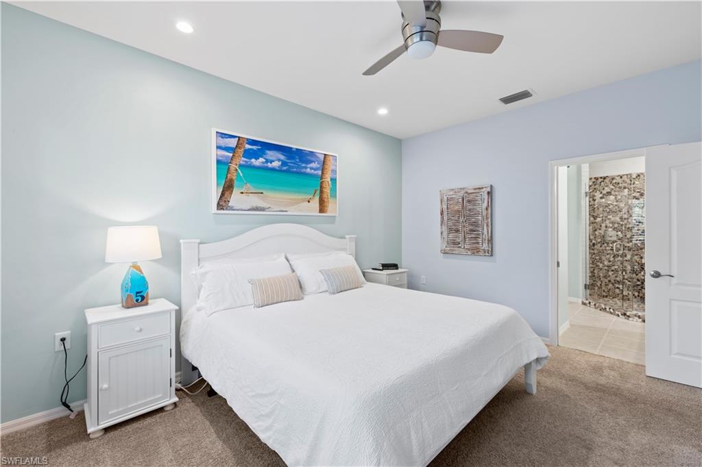 1285 Sweetwater Cove, Unit 2106 Naples, FL 34110 - Photo 16 of 38 a bedroom with a bed and a painting on the wall