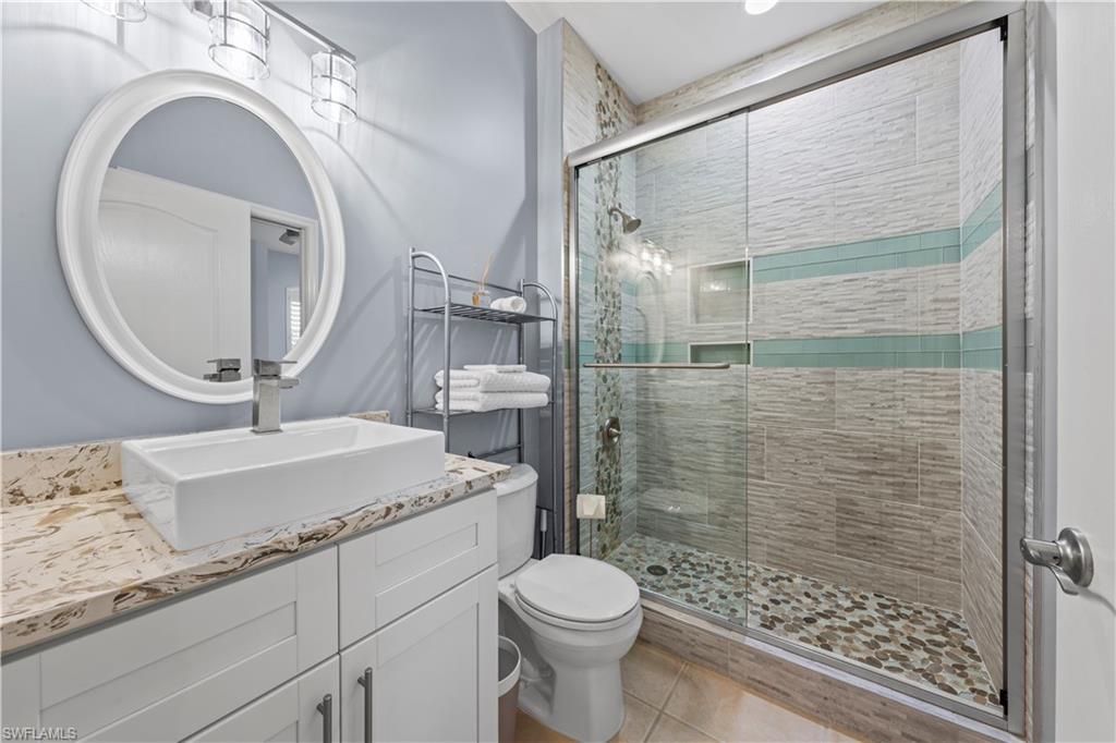 1285 Sweetwater Cove, Unit 2106 Naples, FL 34110 - Photo 20 of 38 a bathroom with a granite countertop sink mirror vanity and toilet