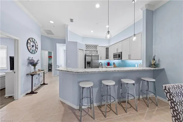 a kitchen with cabinets and chairs