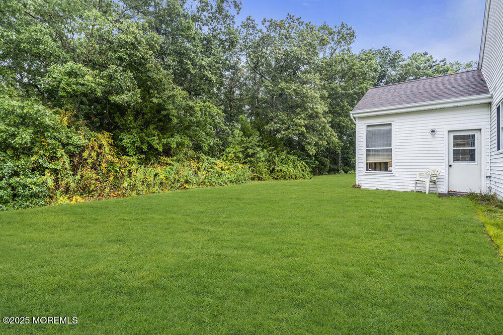 80 Quail Road Barnegat, NJ 08005 - Photo 23 of 27 a backyard of a house with plants and large tree